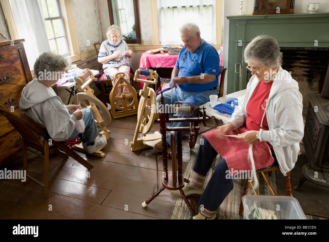 Four elderly people spinning wool into yarn Nellis Tavern historic site St Johnsville New York state Montgomery County Stock Photo
