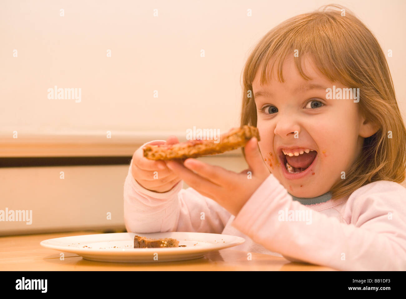 Three year old girl with peanut butter and jam toast Stock Photo Alamy