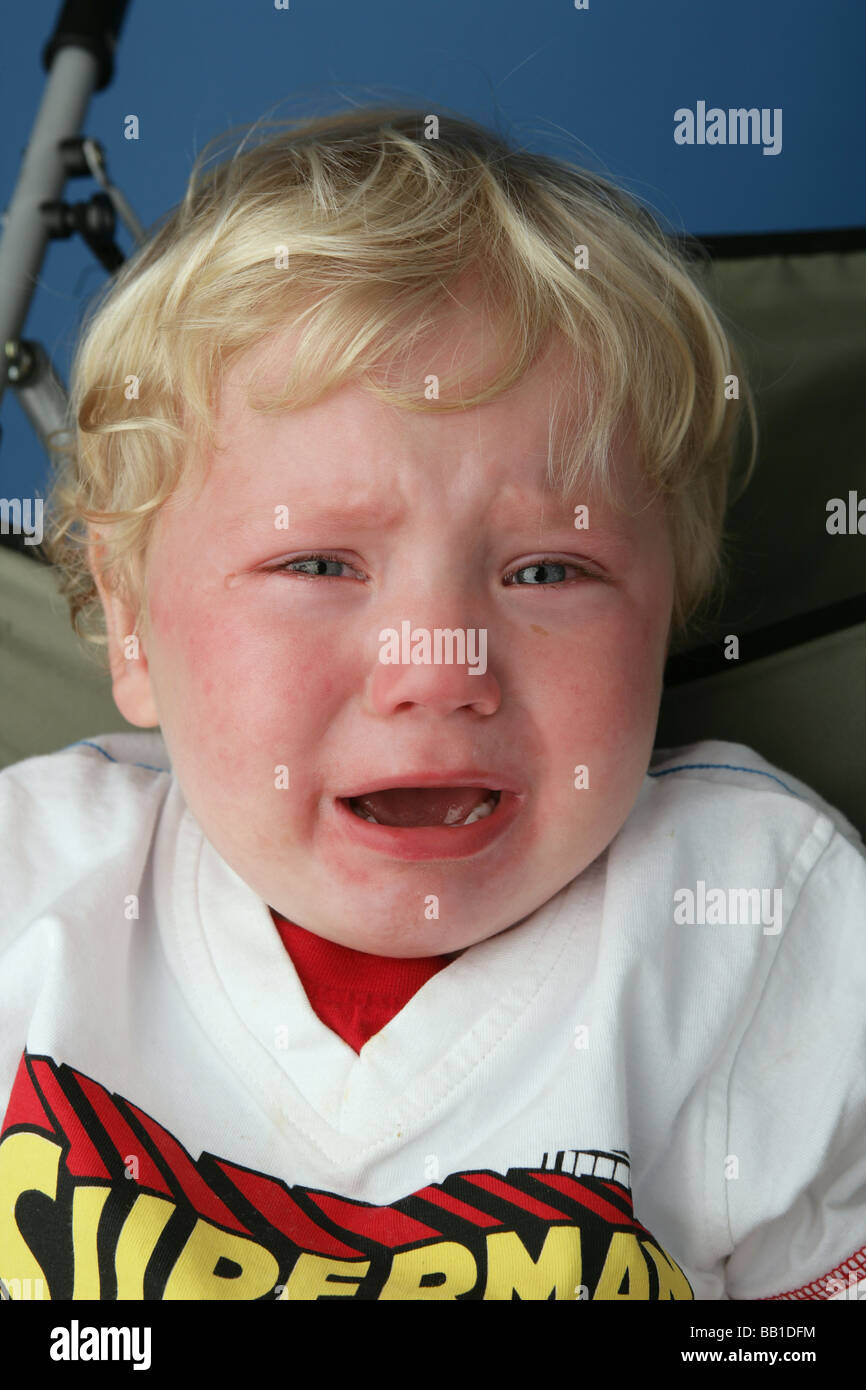 Blonde haired child crying with tears in his eyes Stock Photo Alamy
