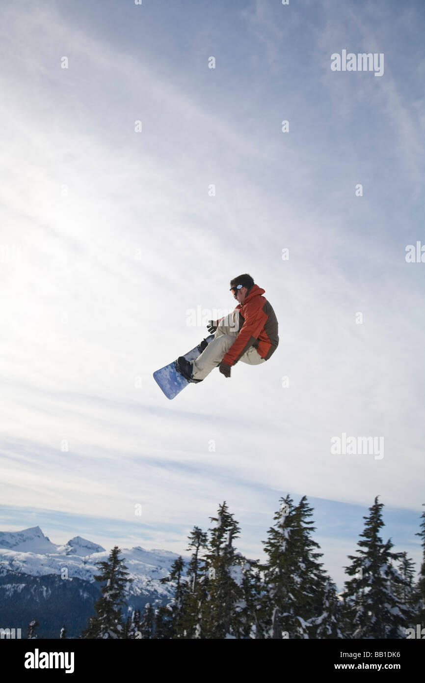 Man snowboarding, jumping in midair; Vancouver Island Ranges, British
