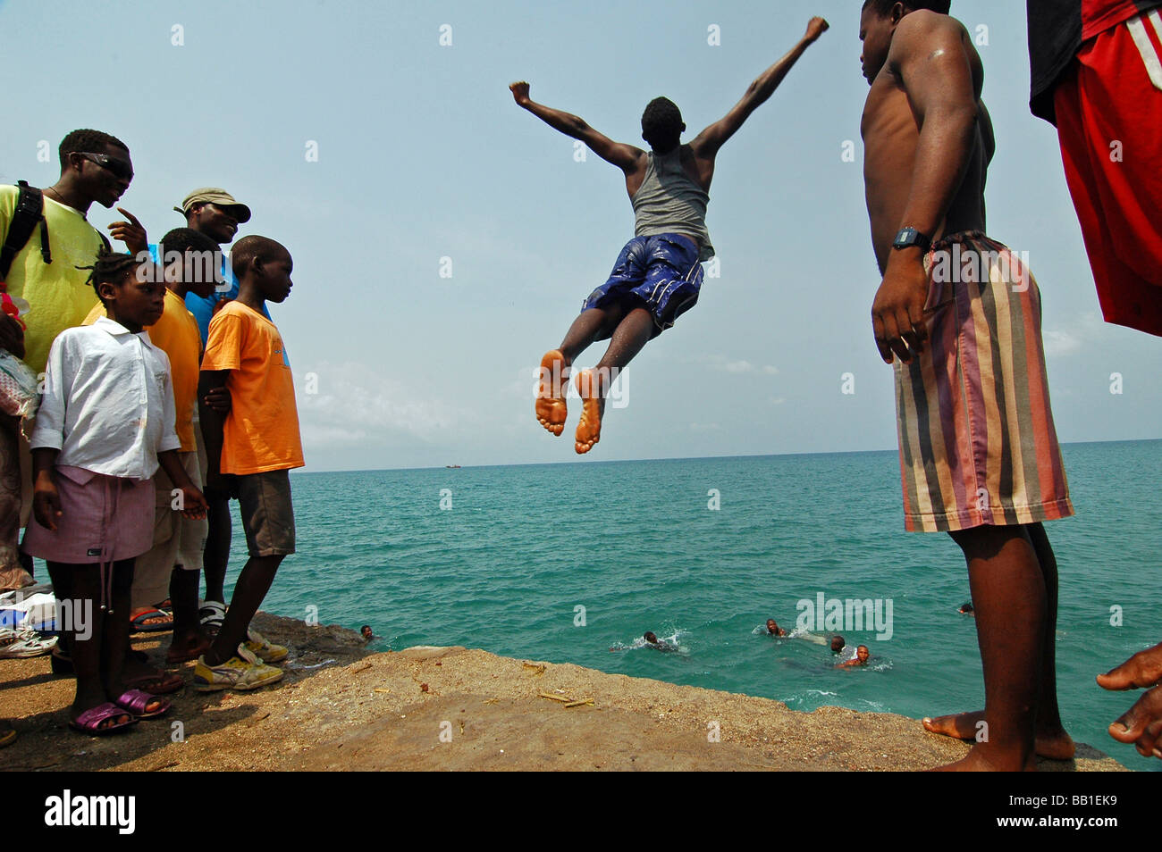 group-of-african-teenage-boys-girls-gathered-on-a-pier-watching-a-BB1EK9.jpg