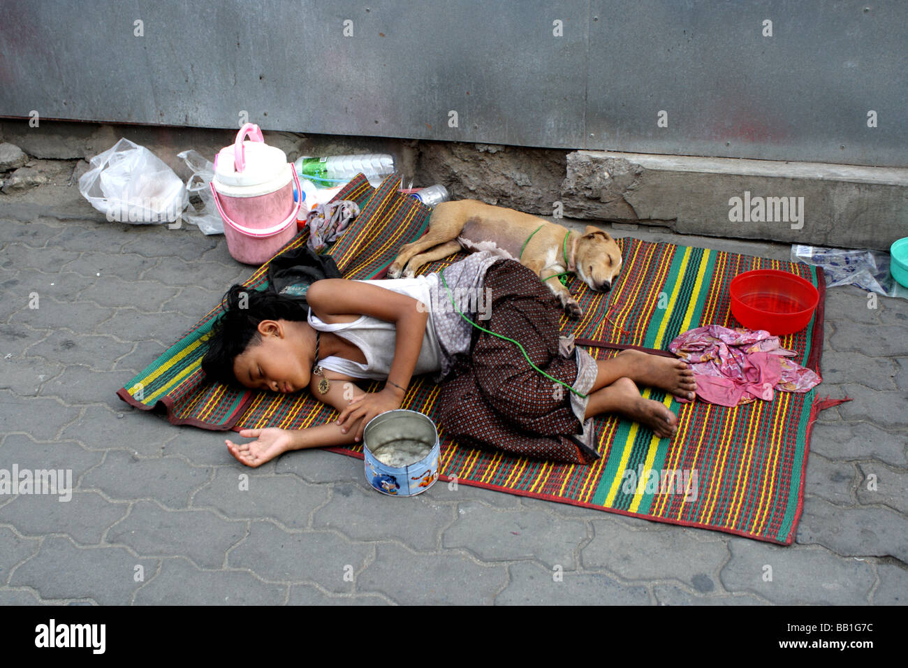 Young thai beggar sleeping on the street in Bangkok , Thailand Stock