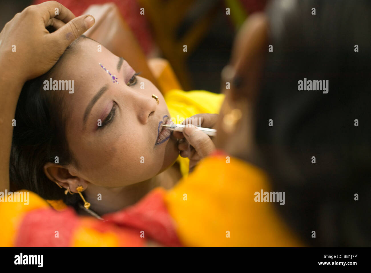 Young woman having makeup applied in brothel beauty salon, Tangail, Bangladesh. Stock Photo