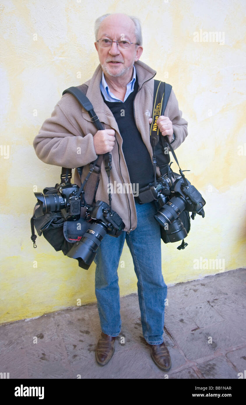 Photographer loaded down with cameras and other photo gear Stock Photo