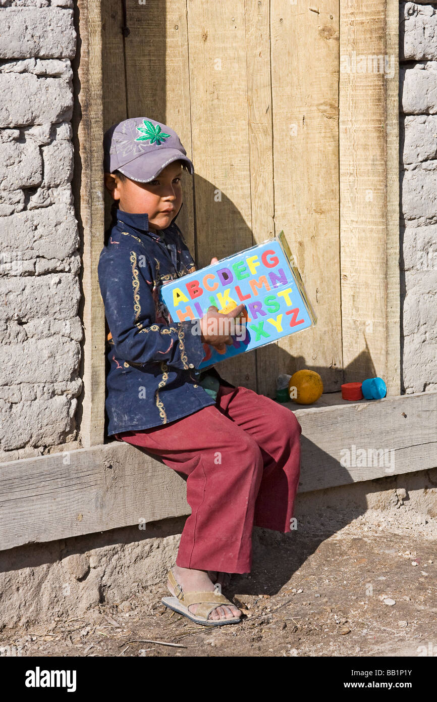 https://c8.alamy.com/comp/BB1P1Y/young-boy-sits-on-step-with-fruit-and-school-supplies-he-got-as-gifts-BB1P1Y.jpg