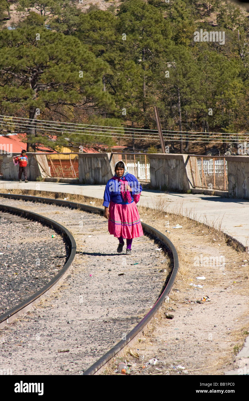 Tarahumara woman walks down tracks at the Divisadero train station of the Copper Canyon railroad line in Mexico. Stock Photo