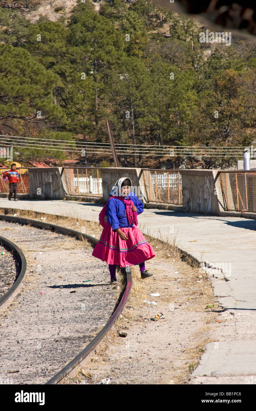 Tarahumara woman walks down tracks at the Divisadero train station of the Copper Canyon railroad line in Mexico. Stock Photo