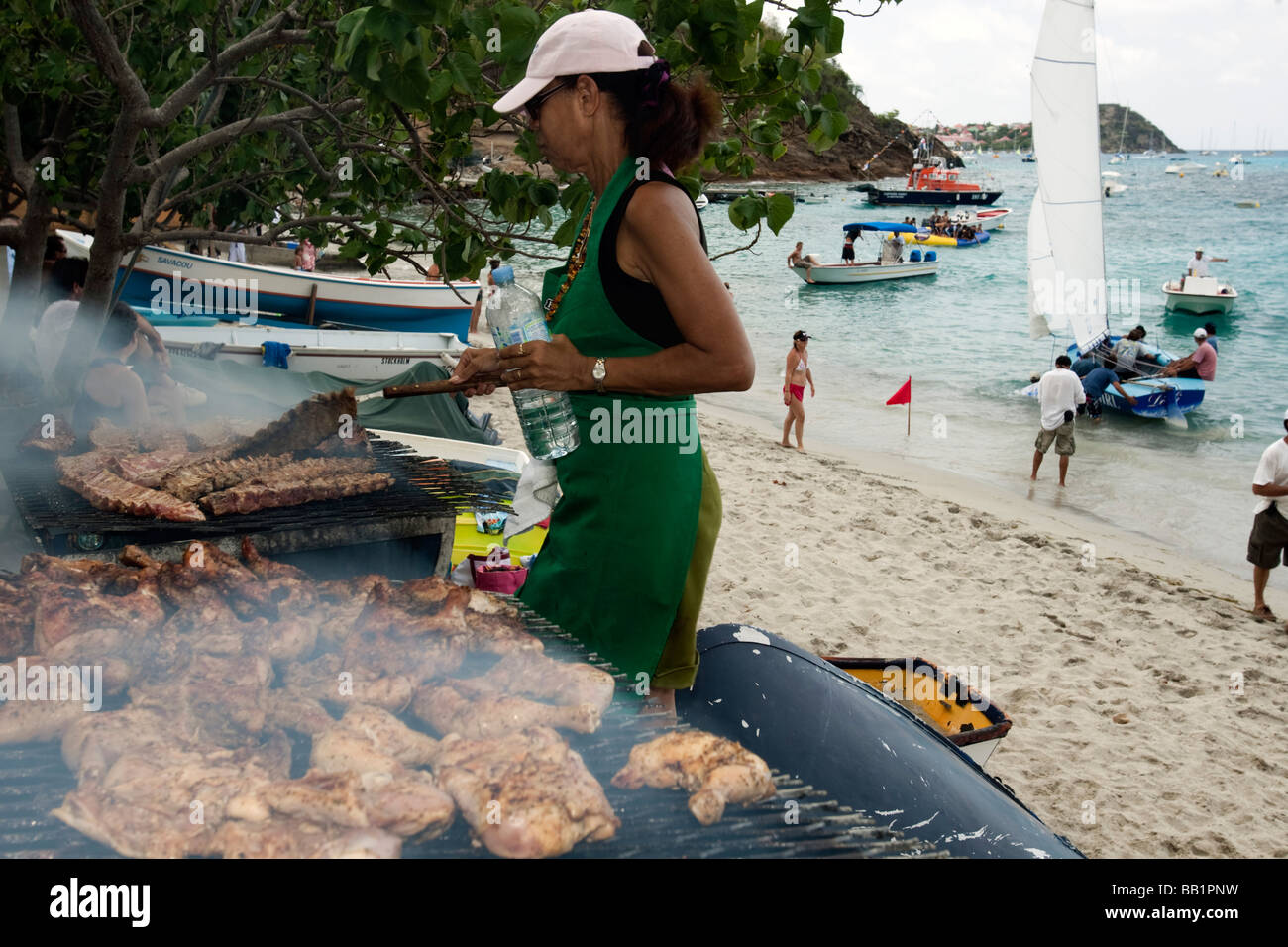 Woman prepares ribs and chicken barbecue Saint Louis Festival Corossol St Barts Stock Photo