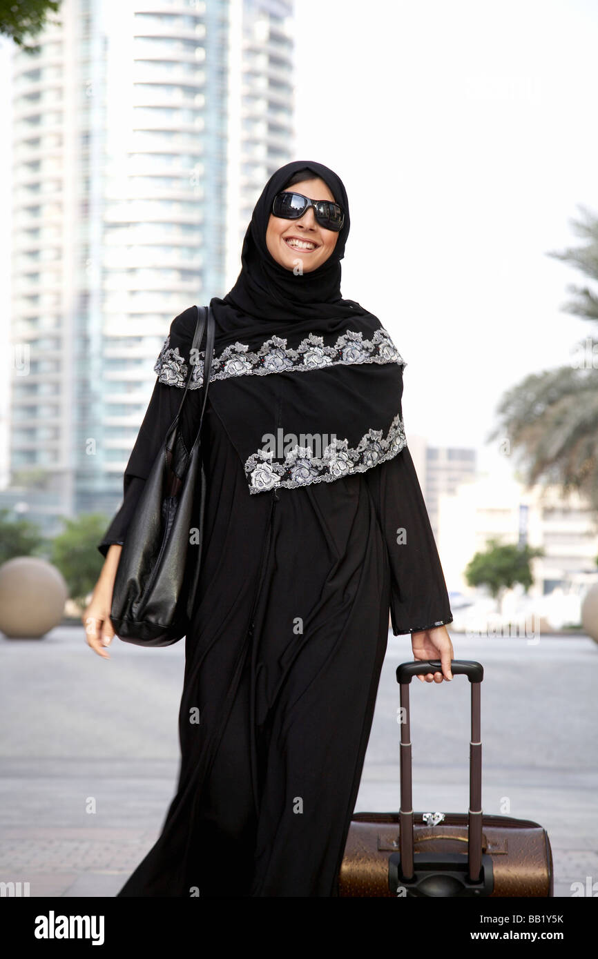 Woman with luggage in the Dubai marina, Dubai, UAE Stock Photo Alamy