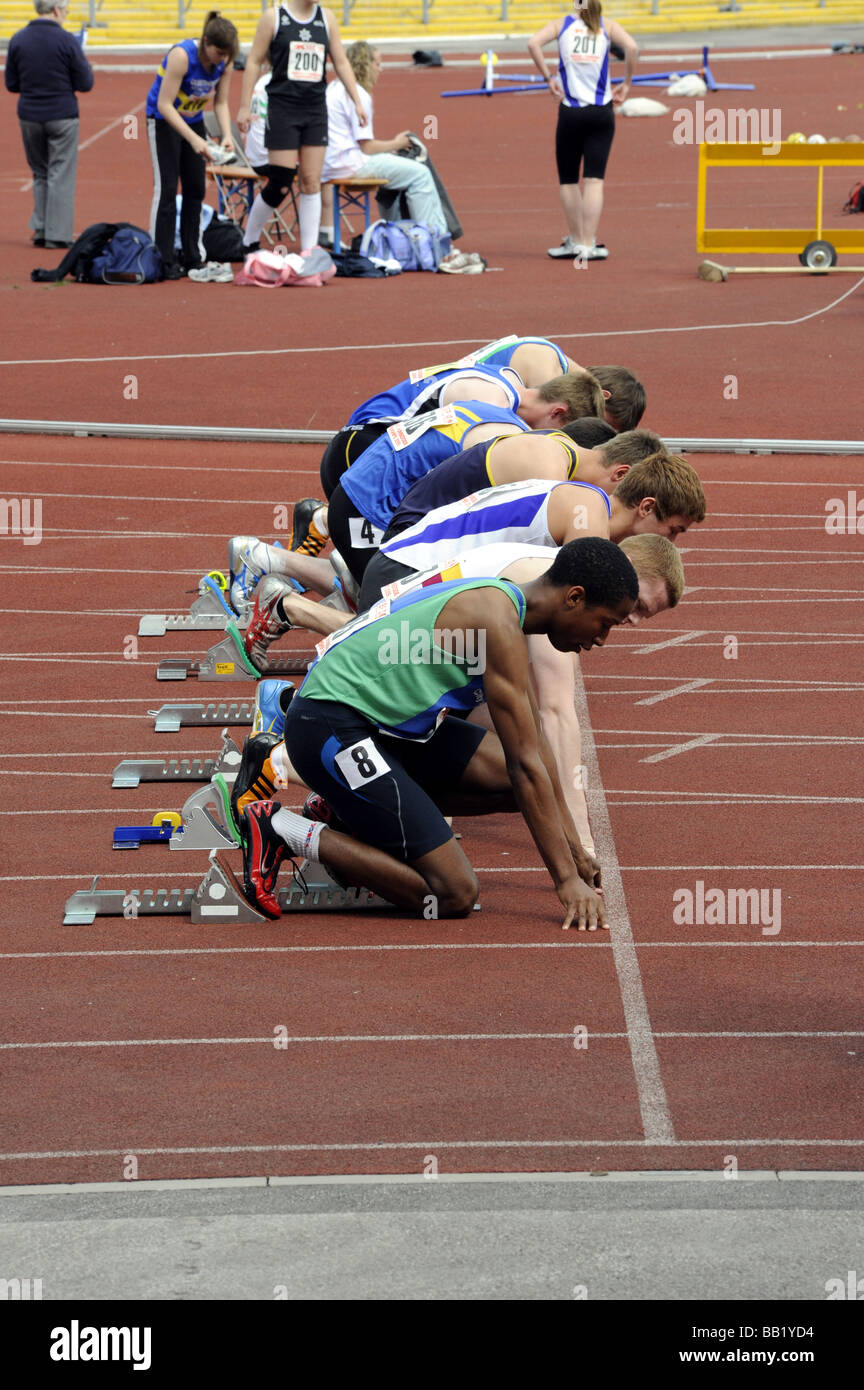 Athletes at start of 100 metre race Stock Photo