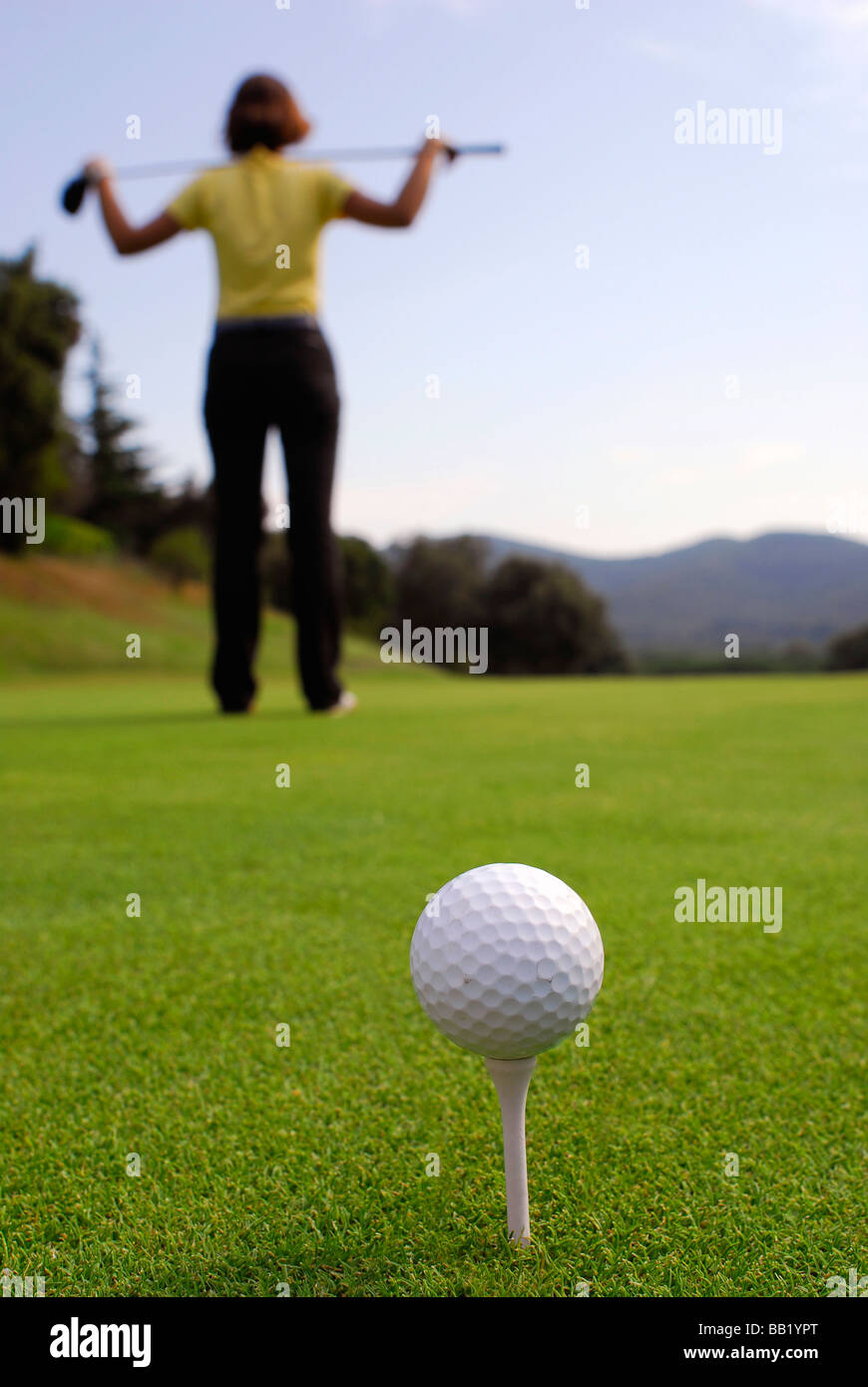 Young woman golfer observing terrain and conditions before hitting Stock Photo