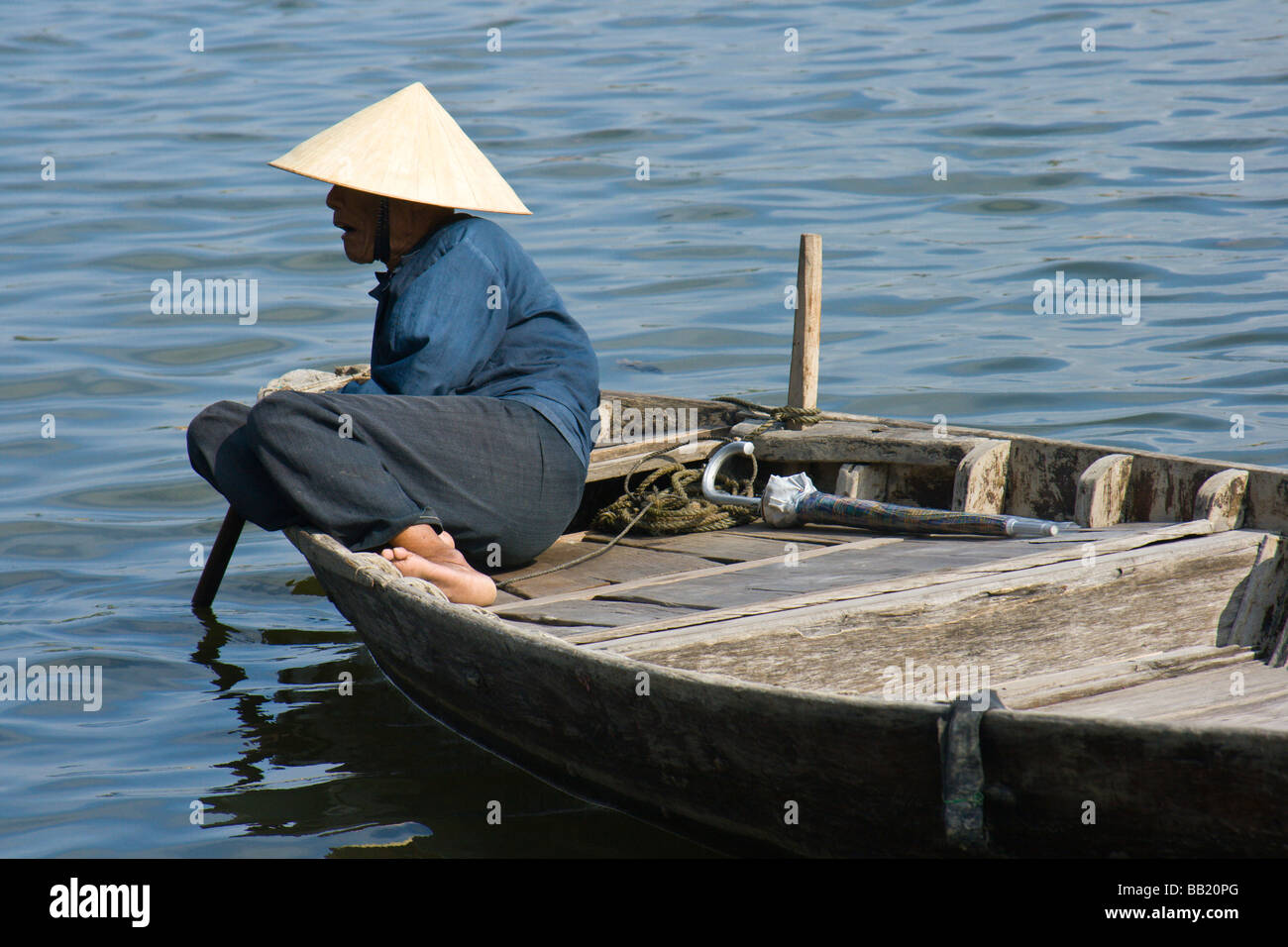 Vietnamese man in a boat, Hoi An, located on the north bank of the Thu ...