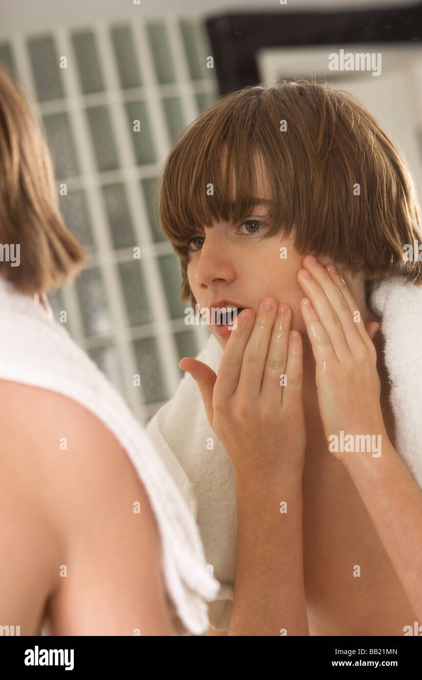 boy-examining-his-face-in-the-bathroom-mirror-stock-photo-alamy