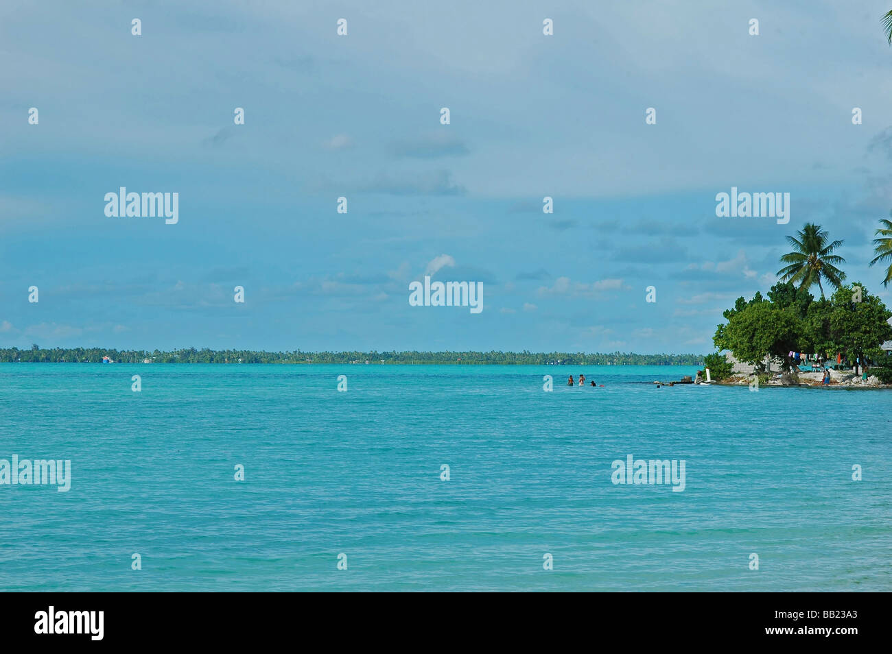 REPUBLIC OF KIRIBATI, South Tarawa. Small island in a blue turquoise sea, with houses and laundry drying under coconut trees Stock Photo