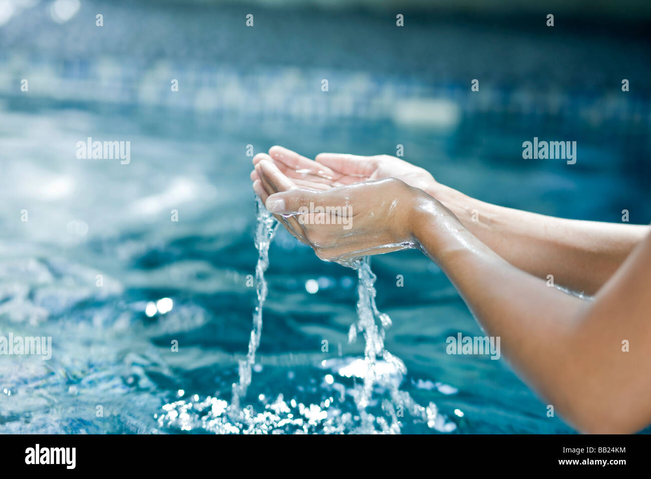 Water dripping from the cupped hands of a woman Stock Photo Alamy