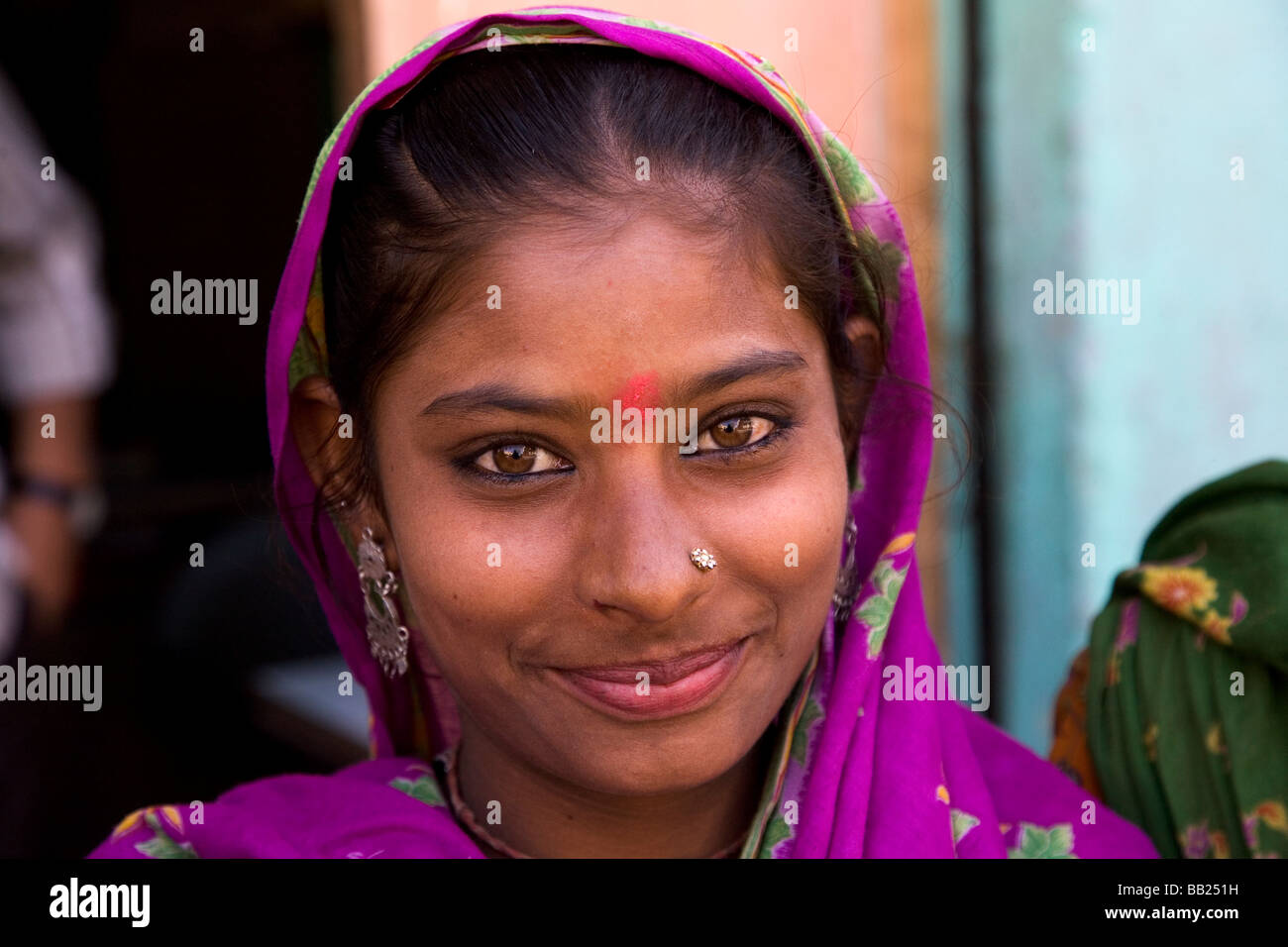 A young tribal woman in the Gujarati city of Rajkot, India. The woman wears a nose stud and a colourful headscarf. Stock Photo