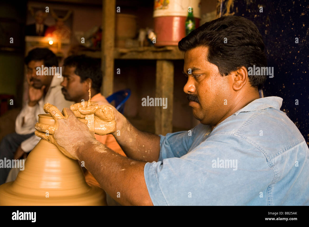 A potters works on a revolving potters wheel in Bangalore, India. A section of the city is known as Pottery Town. Stock Photo