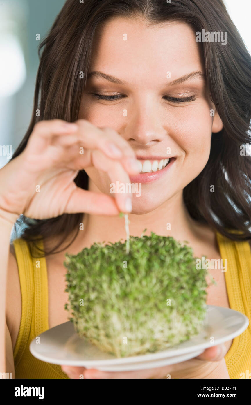 Woman eating bean sprouts and smiling Stock Photo Alamy
