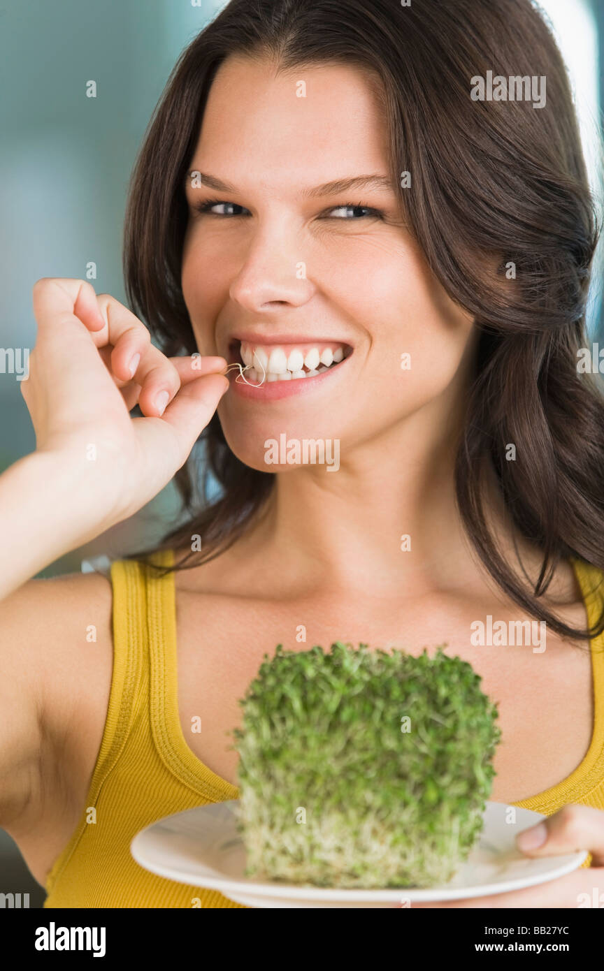 Woman eating bean sprouts and smiling Stock Photo Alamy
