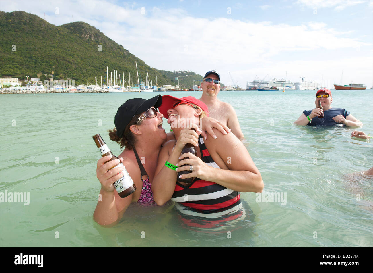 Sint Maarten Philipsburg cruise ship passengers having a morning beer in the shallow water of Philipsburg beach Stock Photo