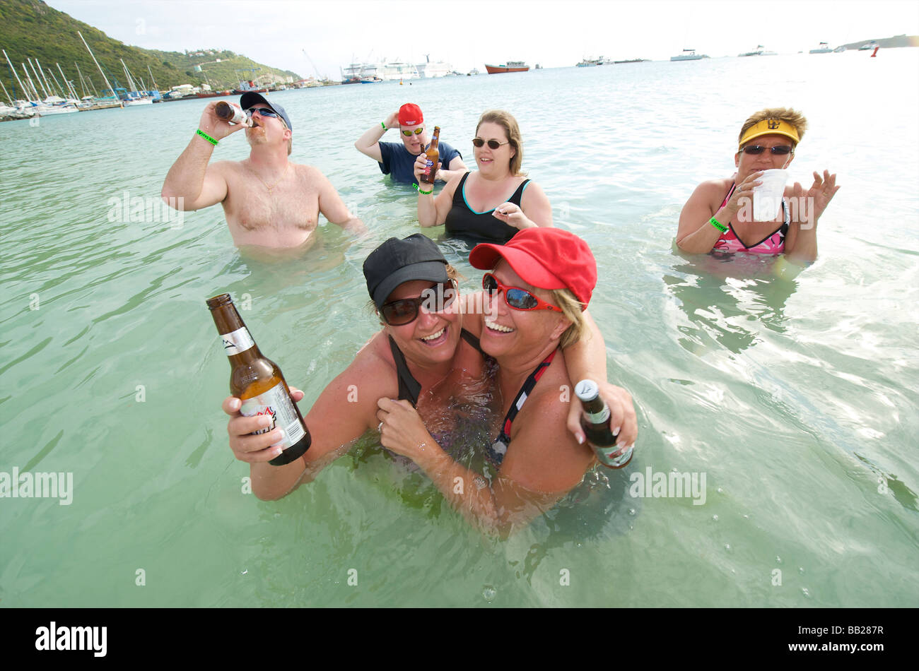 Sint Maarten Philipsburg cruise ship passengers having a morning beer in the shallow water of Philipsburg beach Stock Photo
