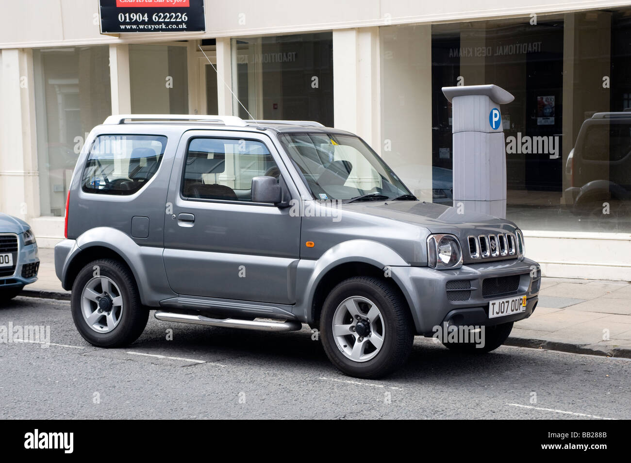 Suzuki Jimny car parked by a parking meter on a city street in England Stock Photo