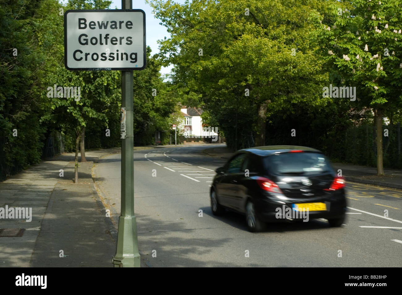 A road sign warns approaching traffic of golfers crossing a suburban road between two sections of Shortlands Golf Course. Stock Photo