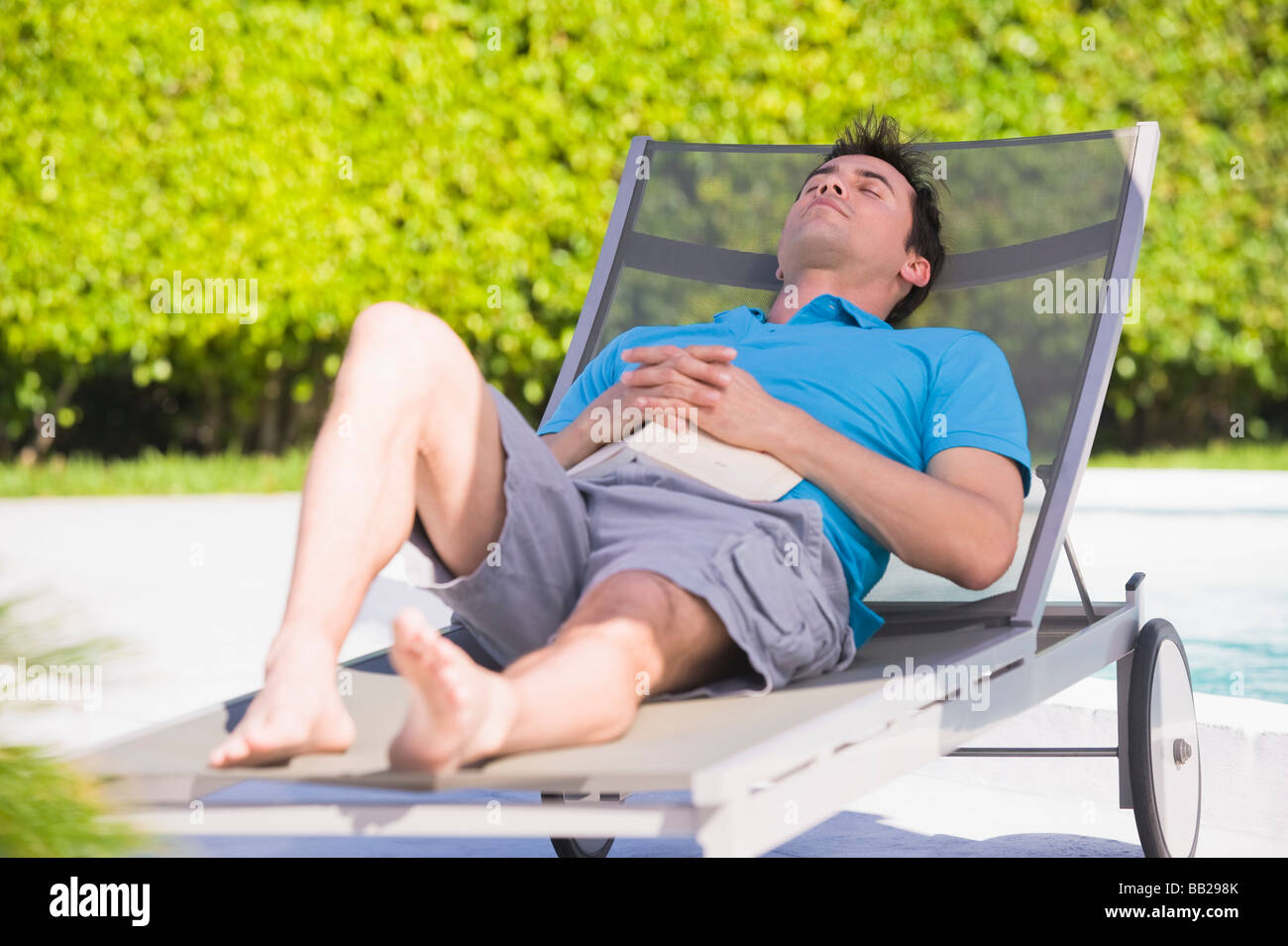 Man resting on a lounge chair Stock Photo - Alamy