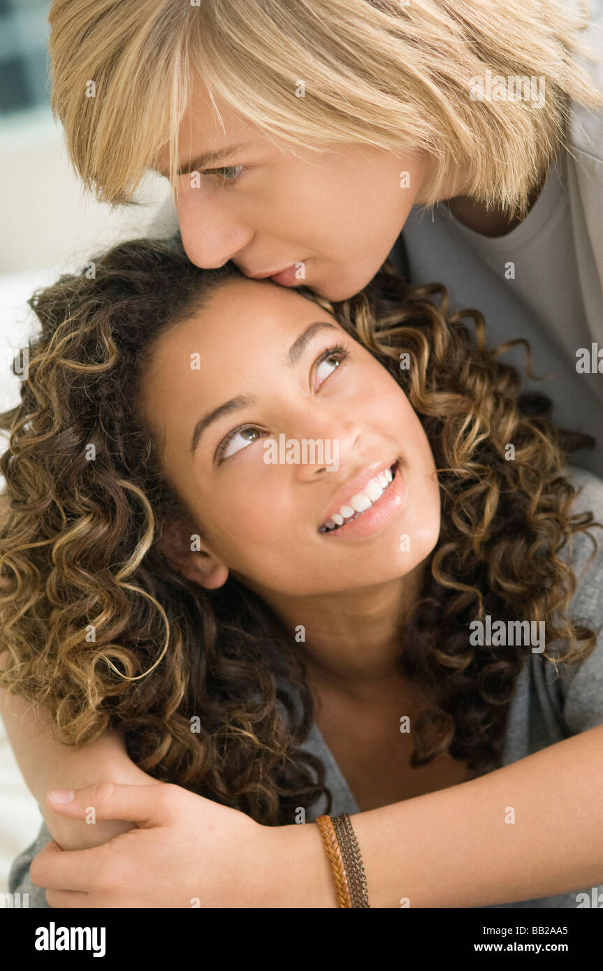 Teenage boy kissing on the forehead of a girl Stock Photo