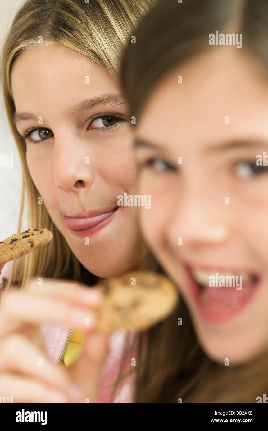 Two girls eating chocolate cookies Stock Photo - Alamy