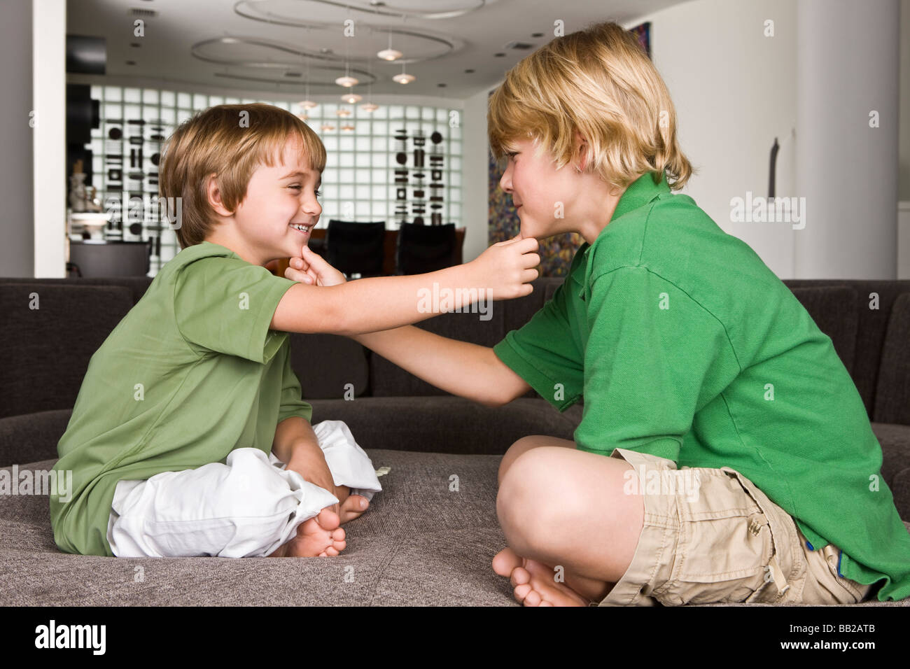 Two boys touching each other's chin and smiling Stock Photo Alamy