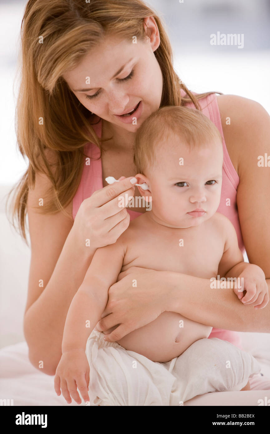 Woman cleaning her daughter's ear with a cotton swab Stock Photo Alamy