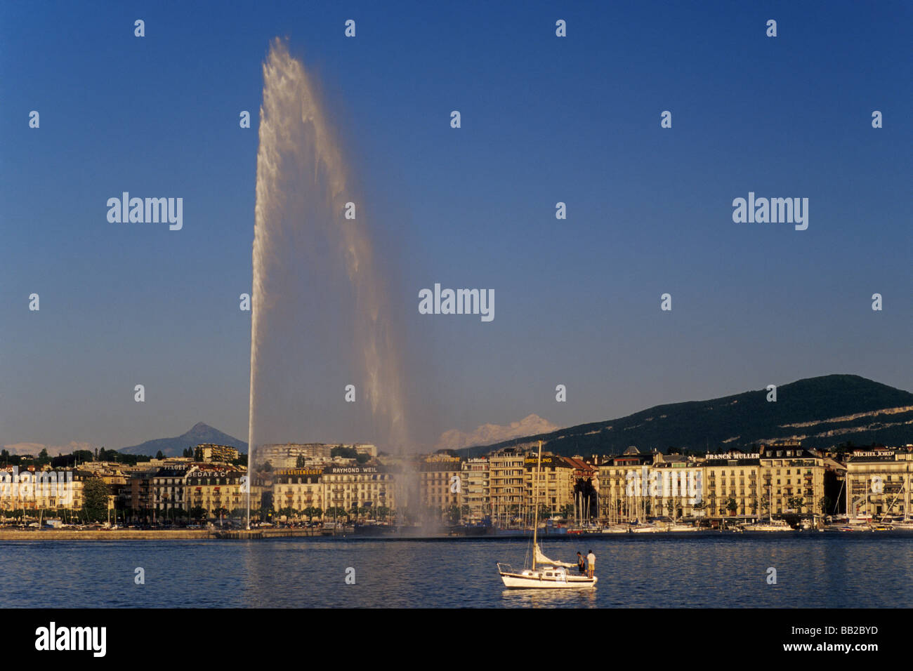 Jet D Eau Fountain At Lake Geneva With Alps In Far Distance Geneva jet-d-eau-fountain-at-lake-geneva-with-alps-in-far-distance-geneva
