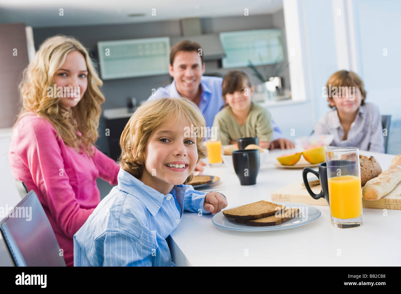 Portrait of a family having breakfast and smiling Stock Photo - Alamy