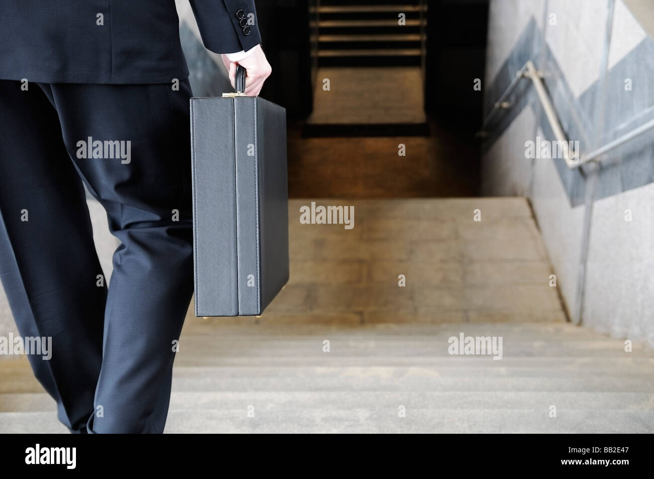 Businessman Carrying a Briefcase Going Down Stairs to a Subway Station Rear View Stock Photo