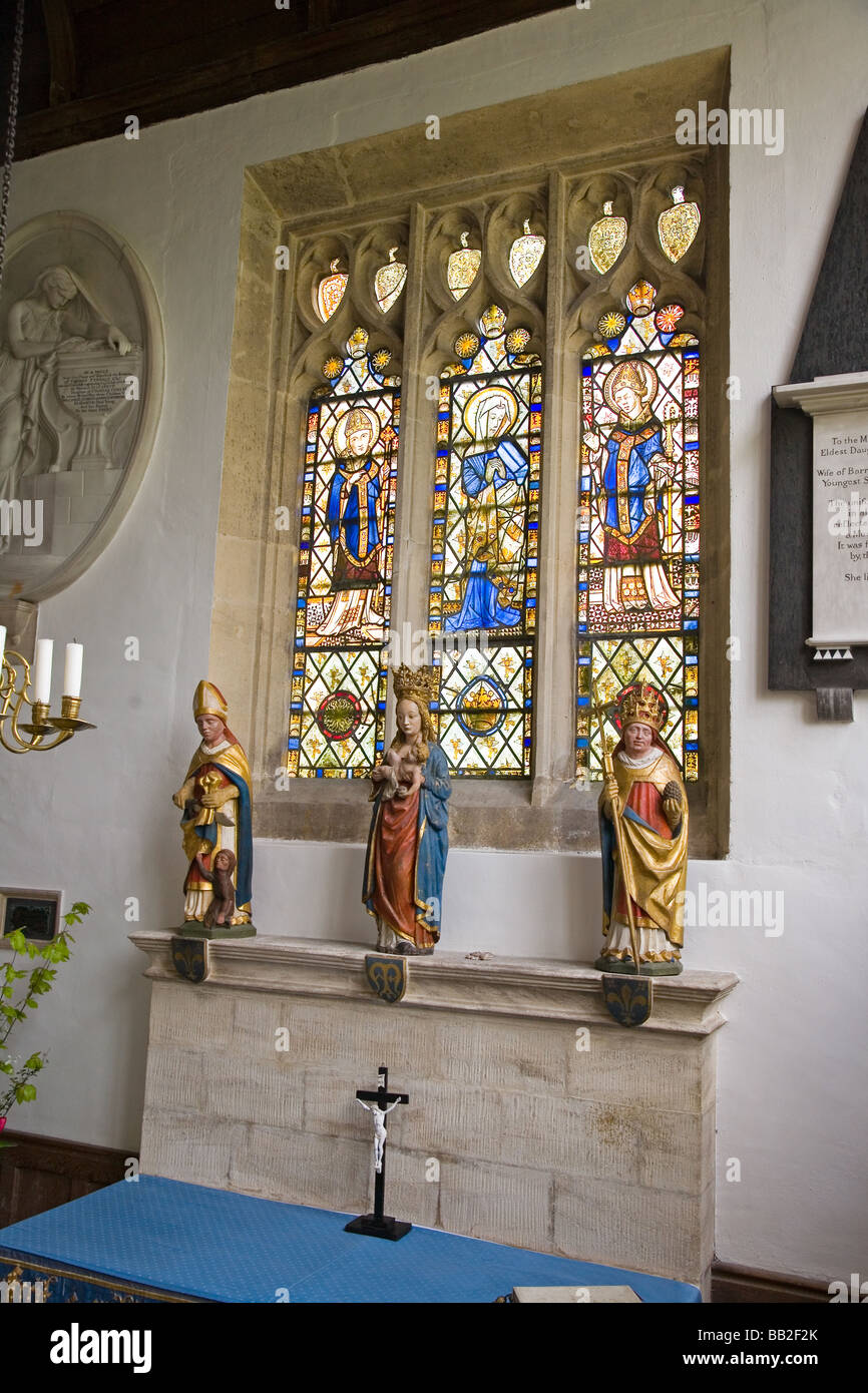 The Lady chapel at North Cerney Church; stained glass window and carved wooden figures c. 1470 Stock Photo