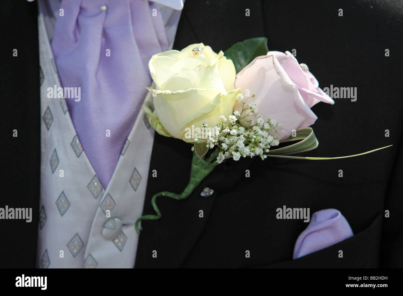 Closeup of rose flower button hole on Grooms suit jacket on wedding day Stock Photo