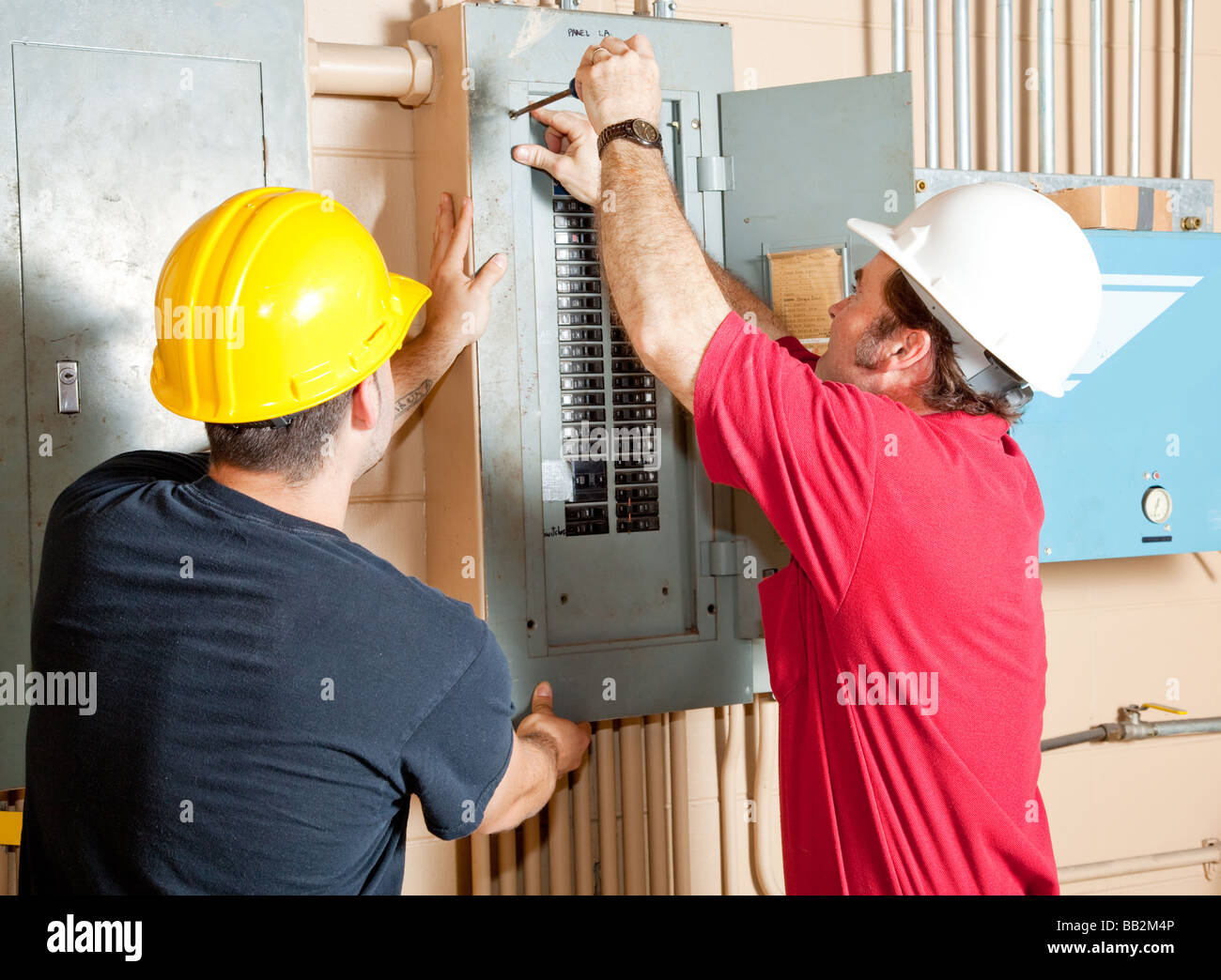 Electricians working together to repair an industrial circuit breaker