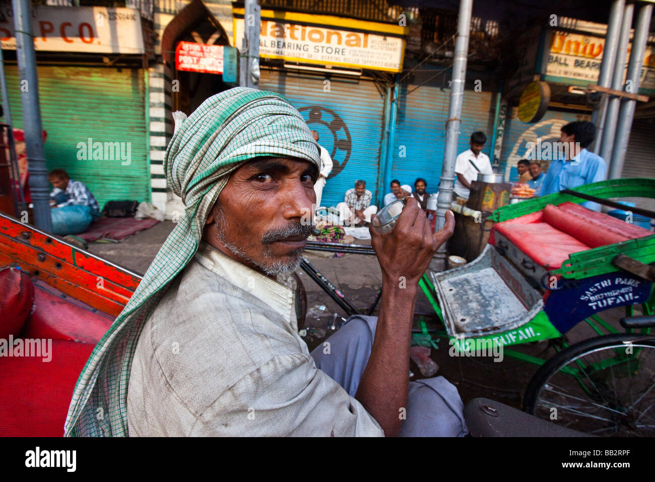 Bicycle Rickshaw Driver Drinking Tea in Old Delhi India Stock Photo