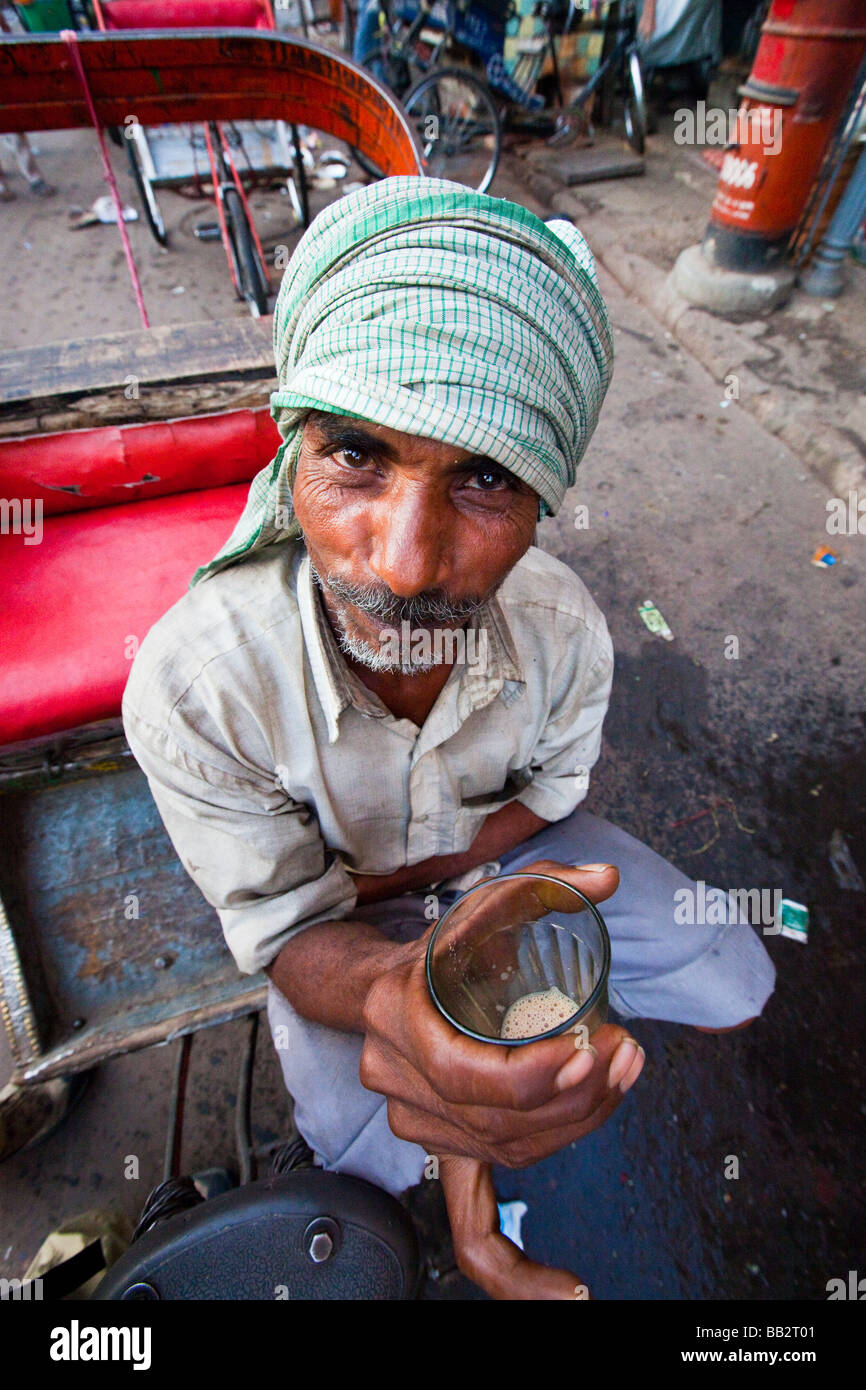 Bicycle Rickshaw Driver Drinking Tea in Old Delhi India Stock Photo
