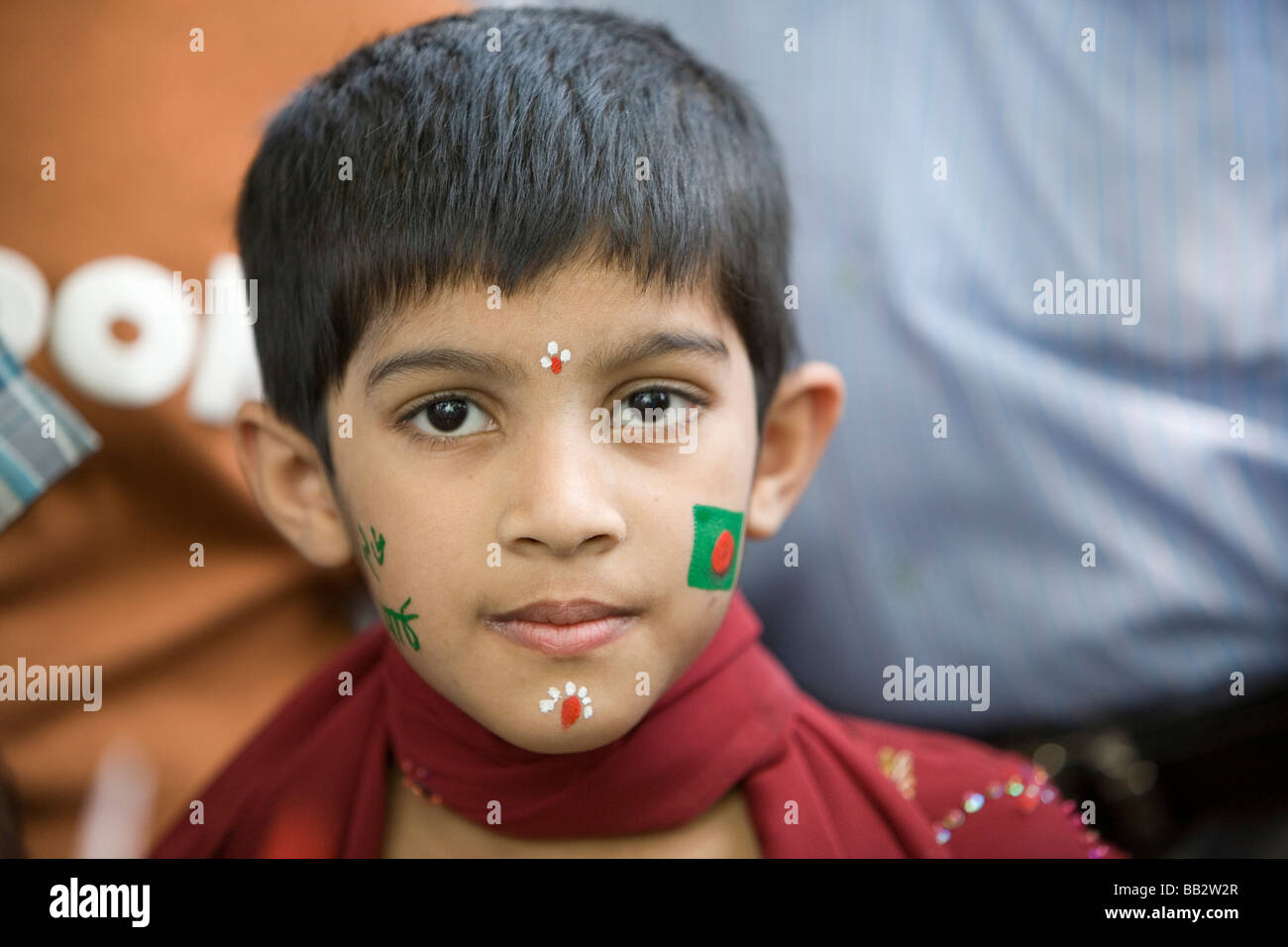Daily Life in Bangladesh; Portrait of a boy with his face painted with the flag of Bangladesh. Stock Photo