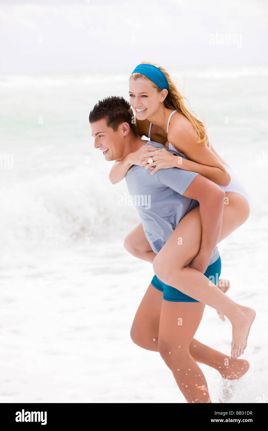 Free Photo  Man giving piggyback ride to woman on the beach