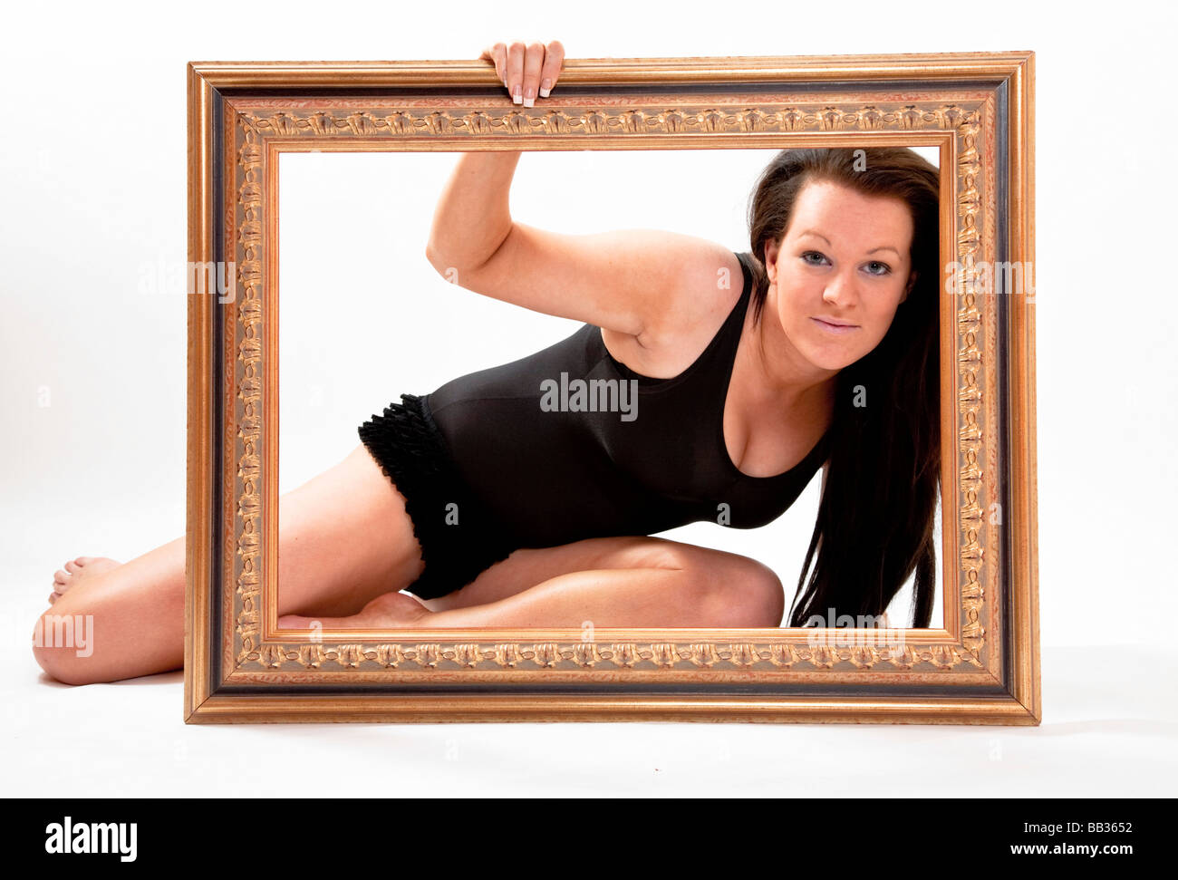 Attractive young woman looking through a picture frame Stock Photo