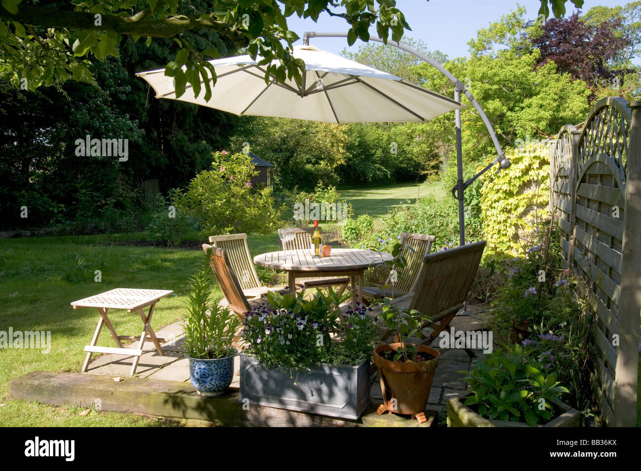 UK. A patio terrace garden table chairs and parasol sun shade ...