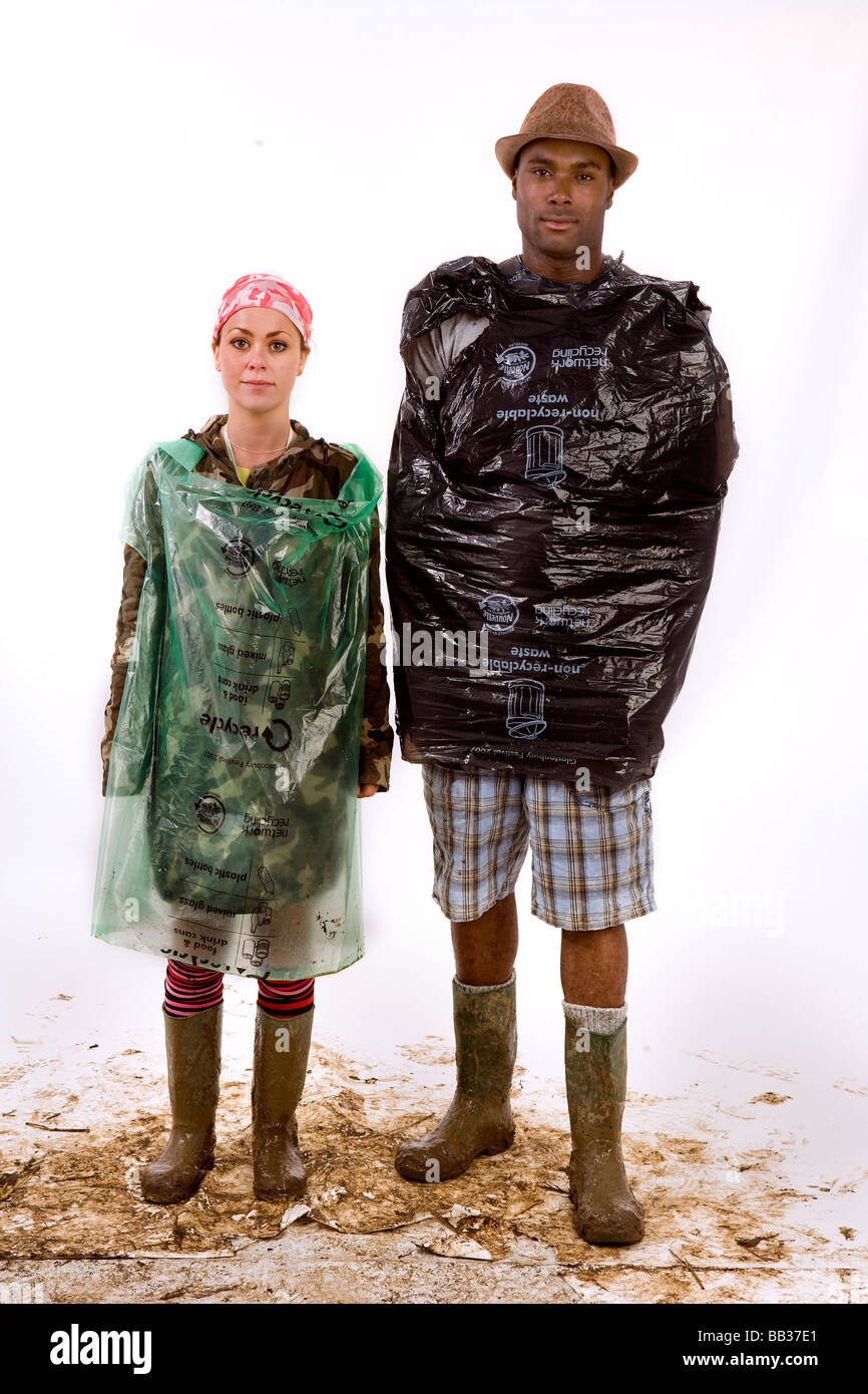 A man a woman using binbags to protect themselves from the rain pose for a photograph at Glastonbury festival, Somerset, UK Stock Photo