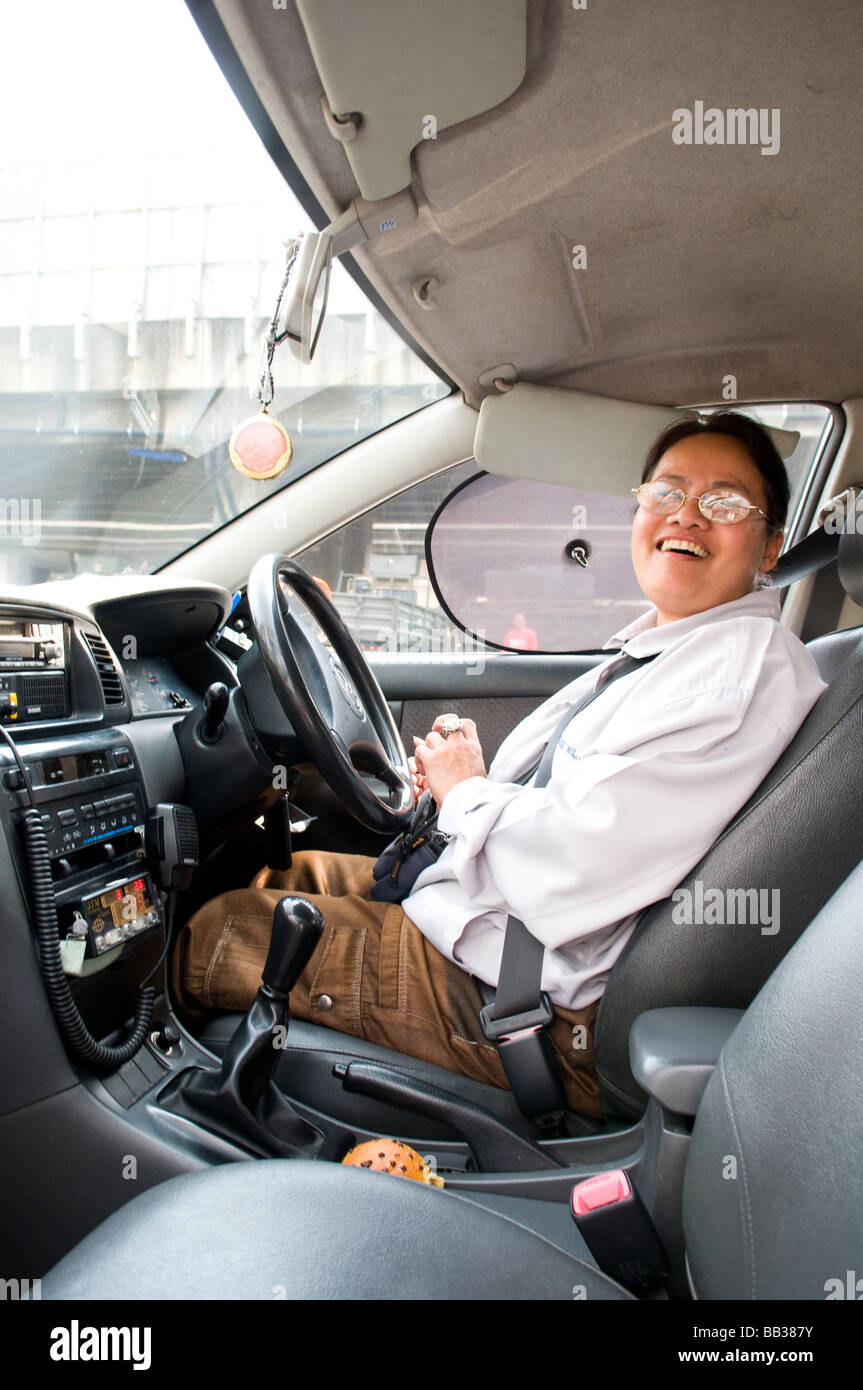Smiling and friendly female metered taxi driver in Bangkok, Thailand. Stock Photo