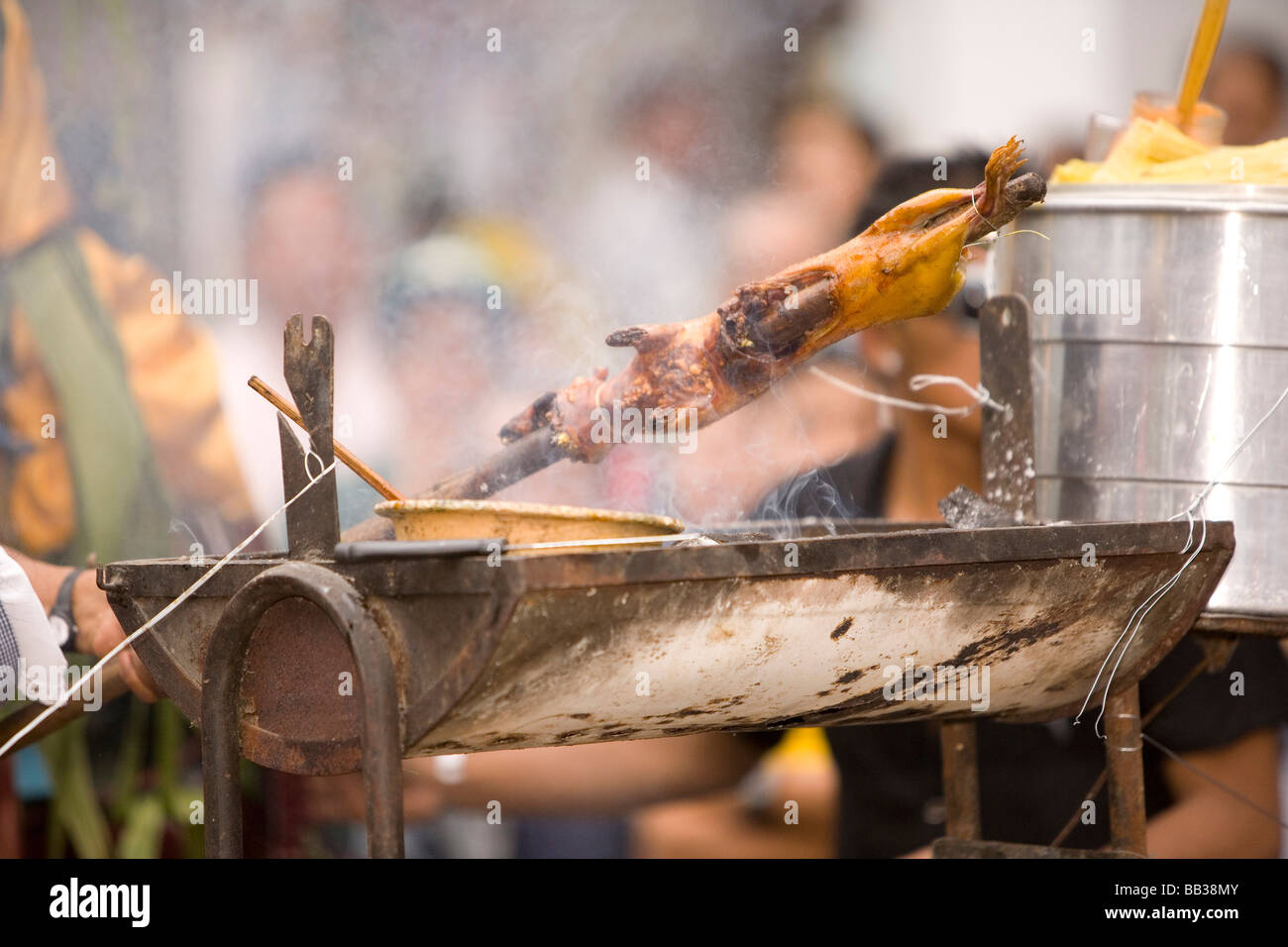 South America, Ecuador, Cuenca.  Cuy  roasting on spit in annual parade & festival to celebrate founding of Cuenca in 1557. Stock Photo