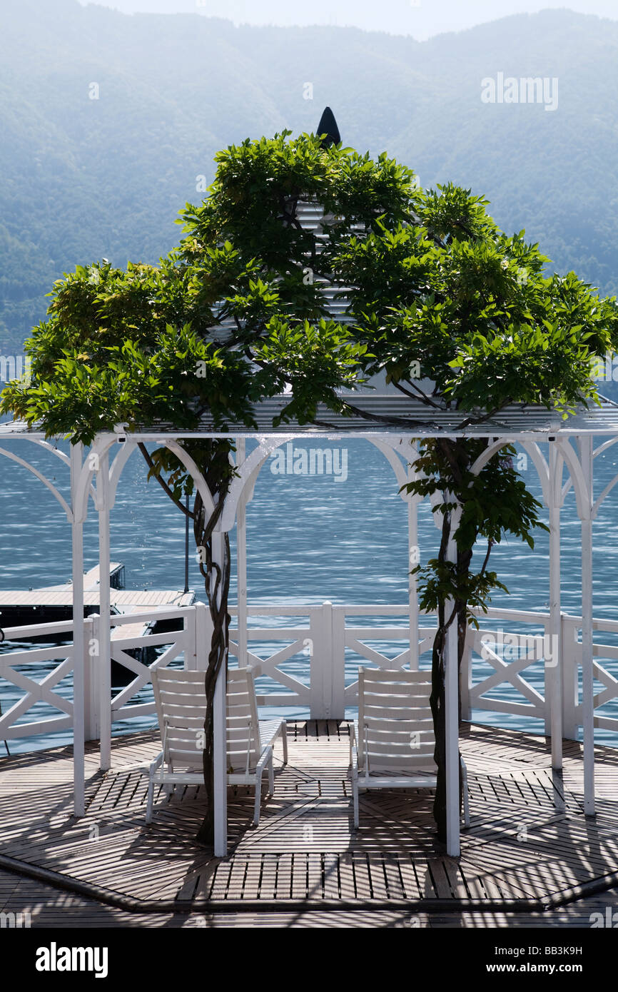 VILLA D'ESTE LUXURY HOTEL WATERFONT TERRACE WITH DOUBLE PLACE CHAIRS. LAKE COMO, CERNOBBIO, ITALY Stock Photo