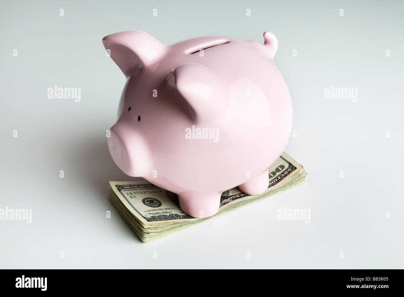 Piggy bank on a stack of 100 dollar bills Stock Photo