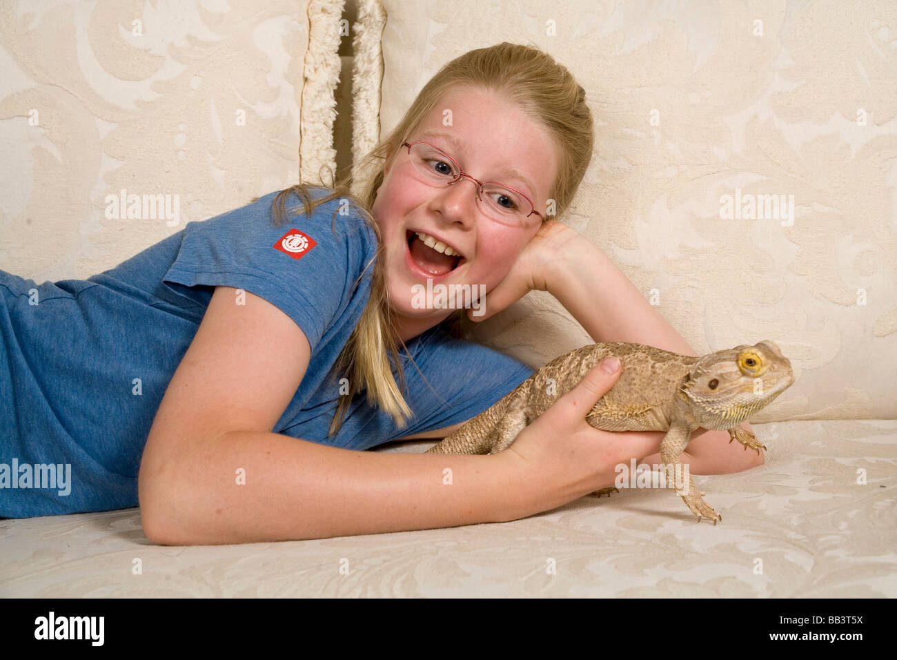 10-11 year old girl wearing eyeglasses laughs surprised expression expressive with Bearded Dragon children having fun  MR  © Myrleen Pearson Stock Photo